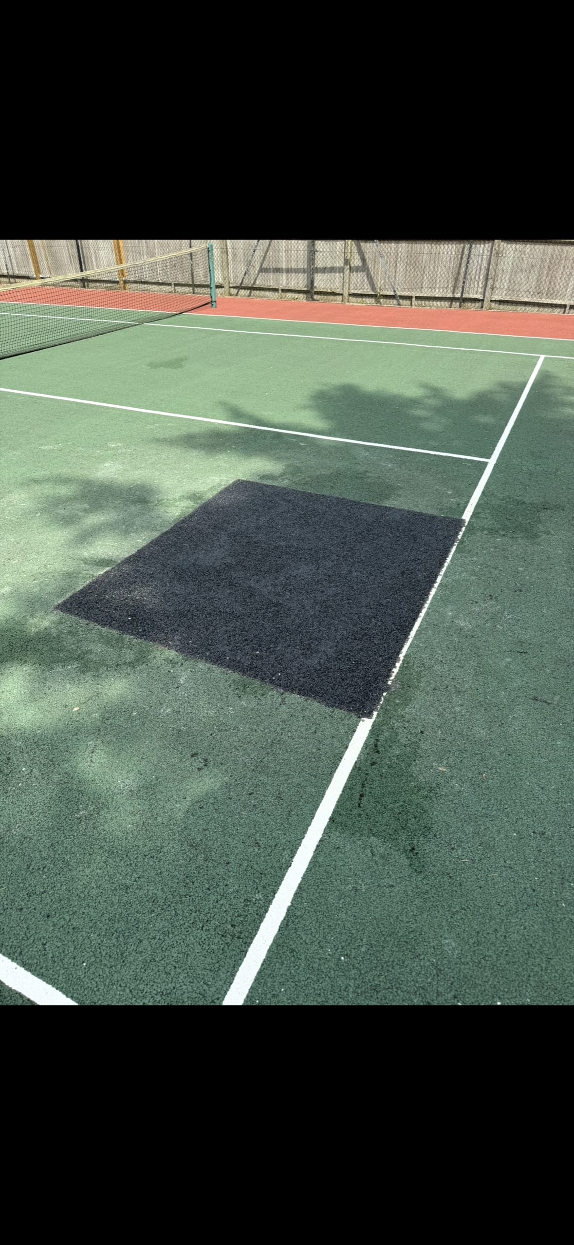 sunny tennis court infront of building