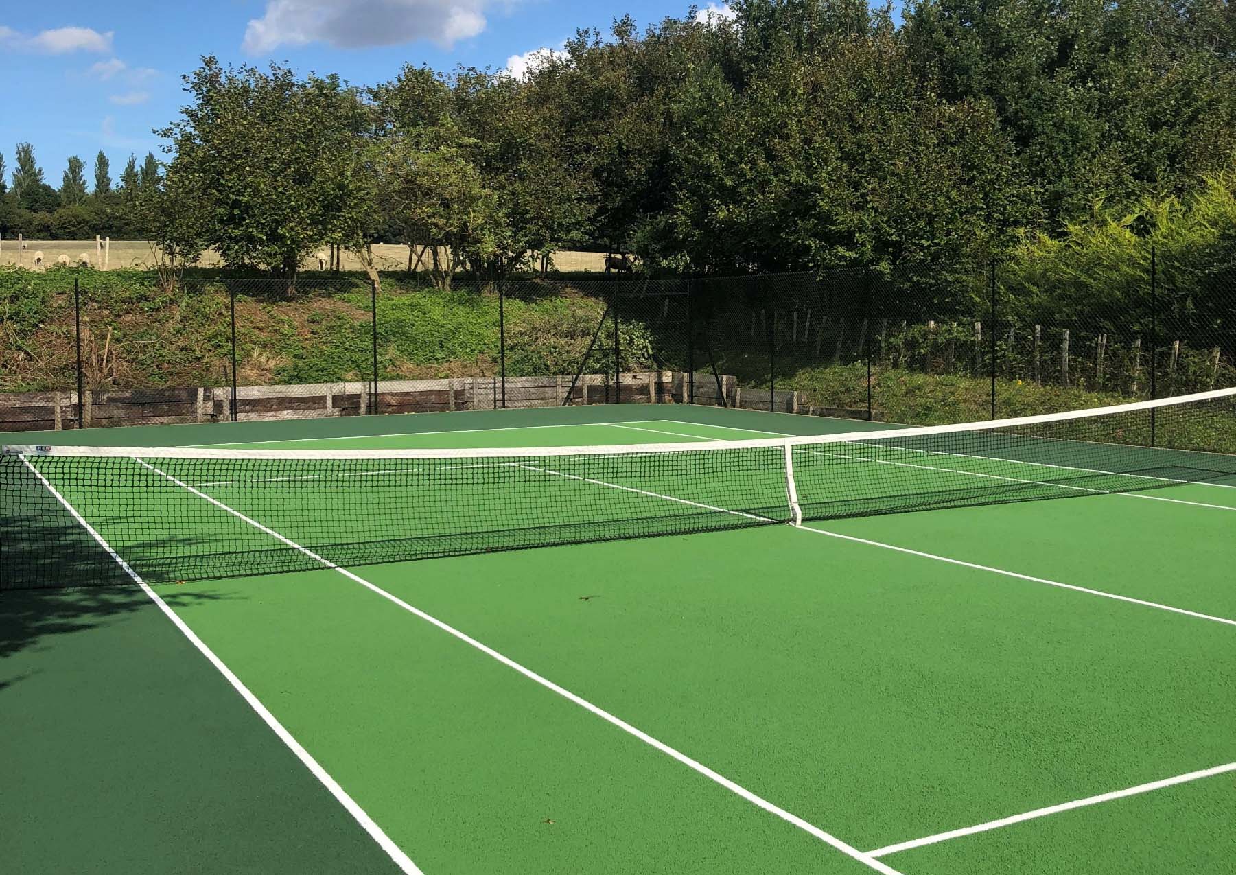 sunny tennis court infront of building